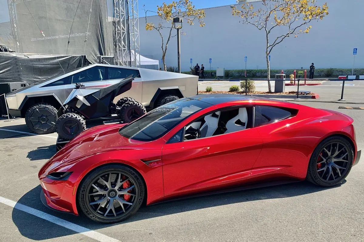 Kırmızı Tesla Roadster prototipi, arkasında Cybertruck ile park halinde